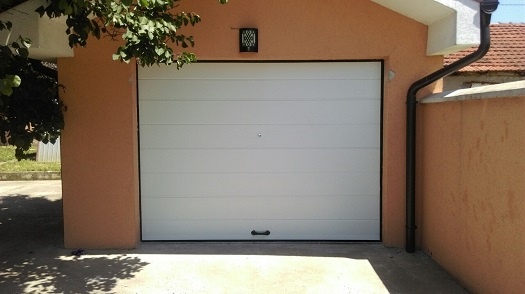 garažna vrata bele boje na narandžastoj fasadi